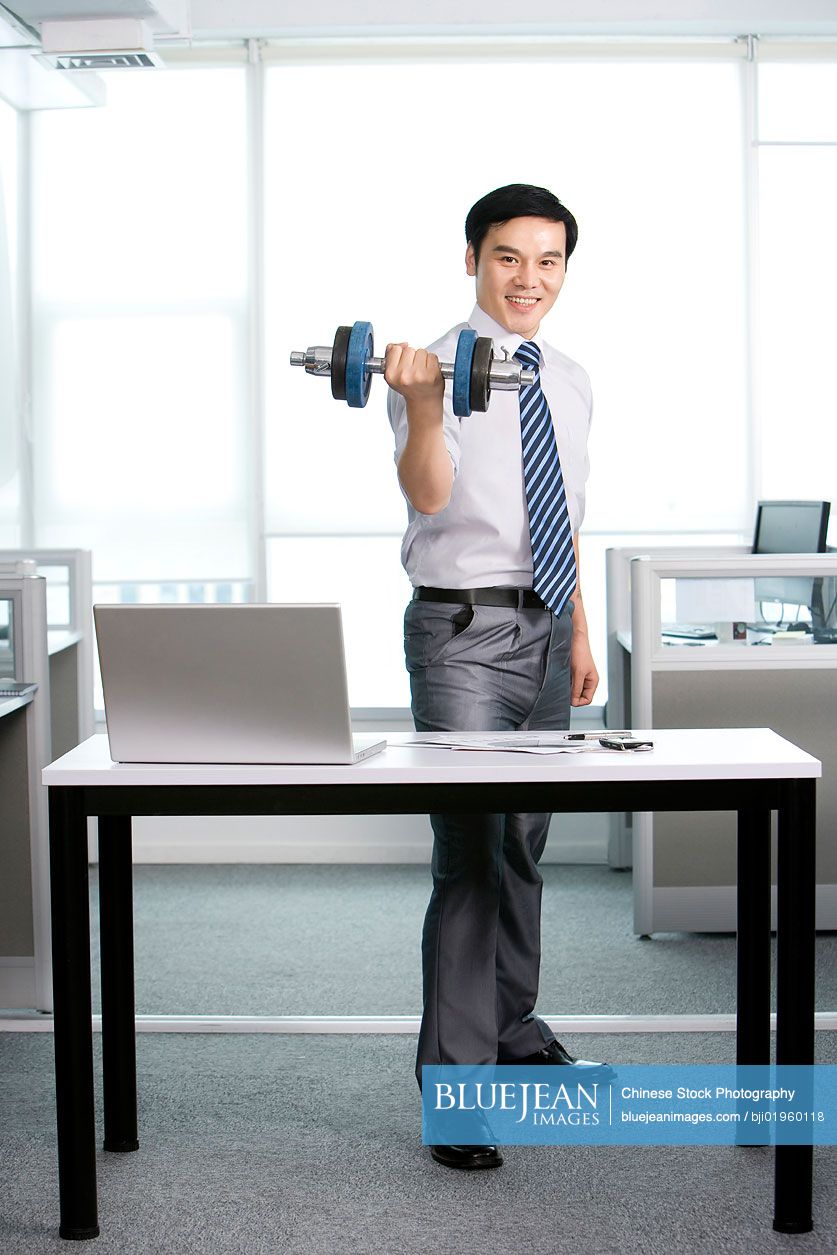 Chinese office worker working out in the office
