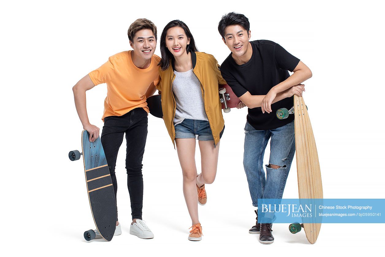 Happy young Chinese people enjoying skateboarding
