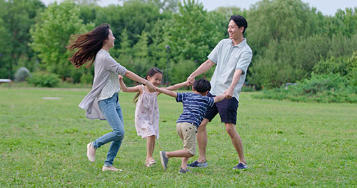 Happy young Chinese family playing on grass,4K
