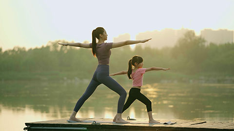 妈妈和女儿在公园练瑜伽