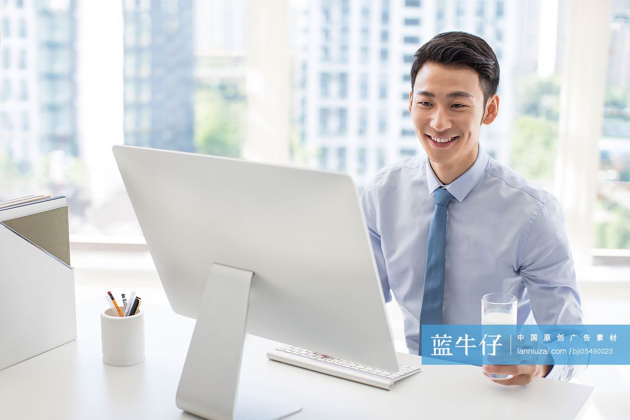 年轻商务男士在办公室使用电脑