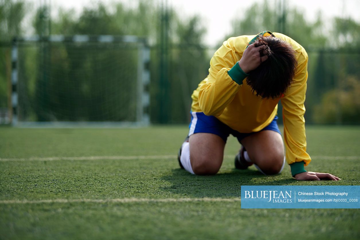 Disappointed Chinese Soccer Player On His Knees