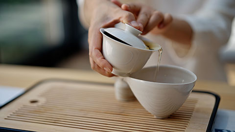 Elegant mature Chinese woman drinking tea in tea room,4K