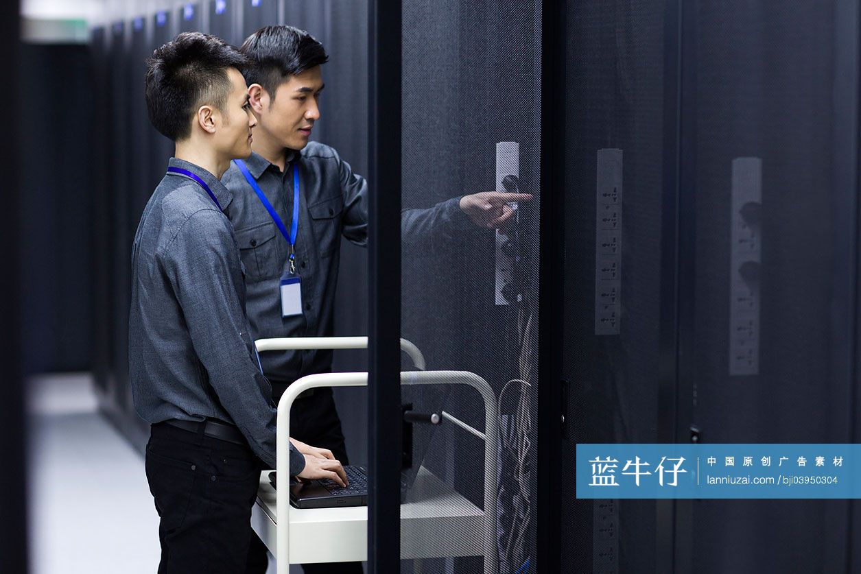 商务男士在机房使用笔记本电脑