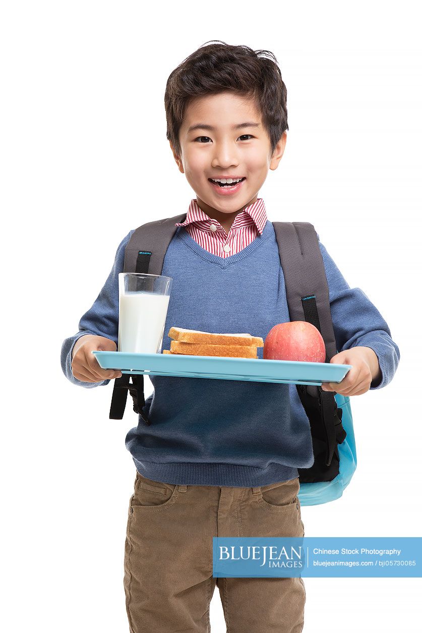 Happy little Chinese boy with breakfast