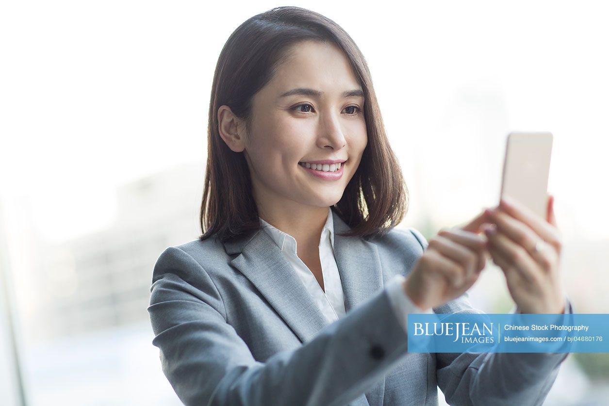 Young Chinese businesswoman using smart phone