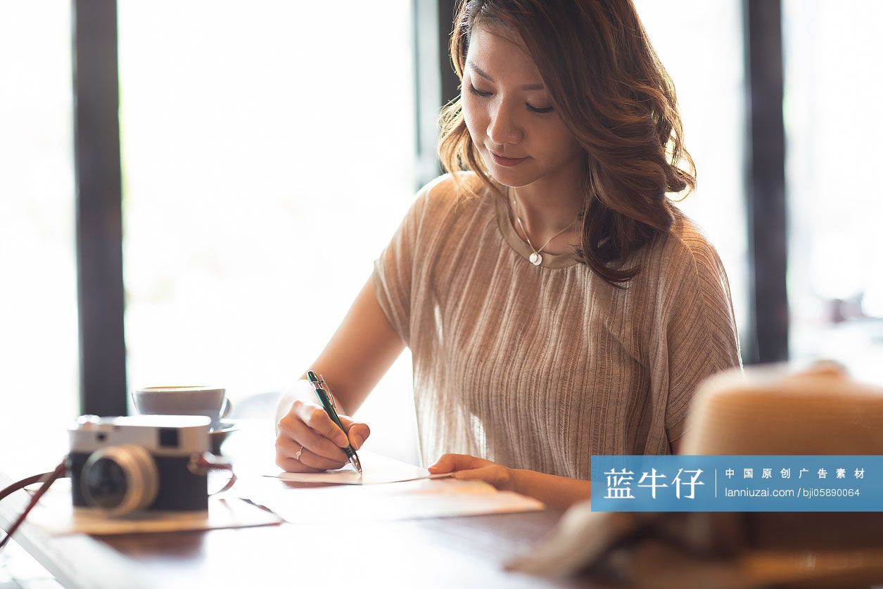 优雅女士在咖啡店写明信片