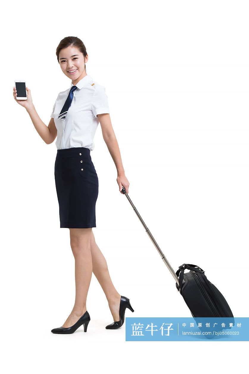 拉行李箱的微笑空姐拿着手机