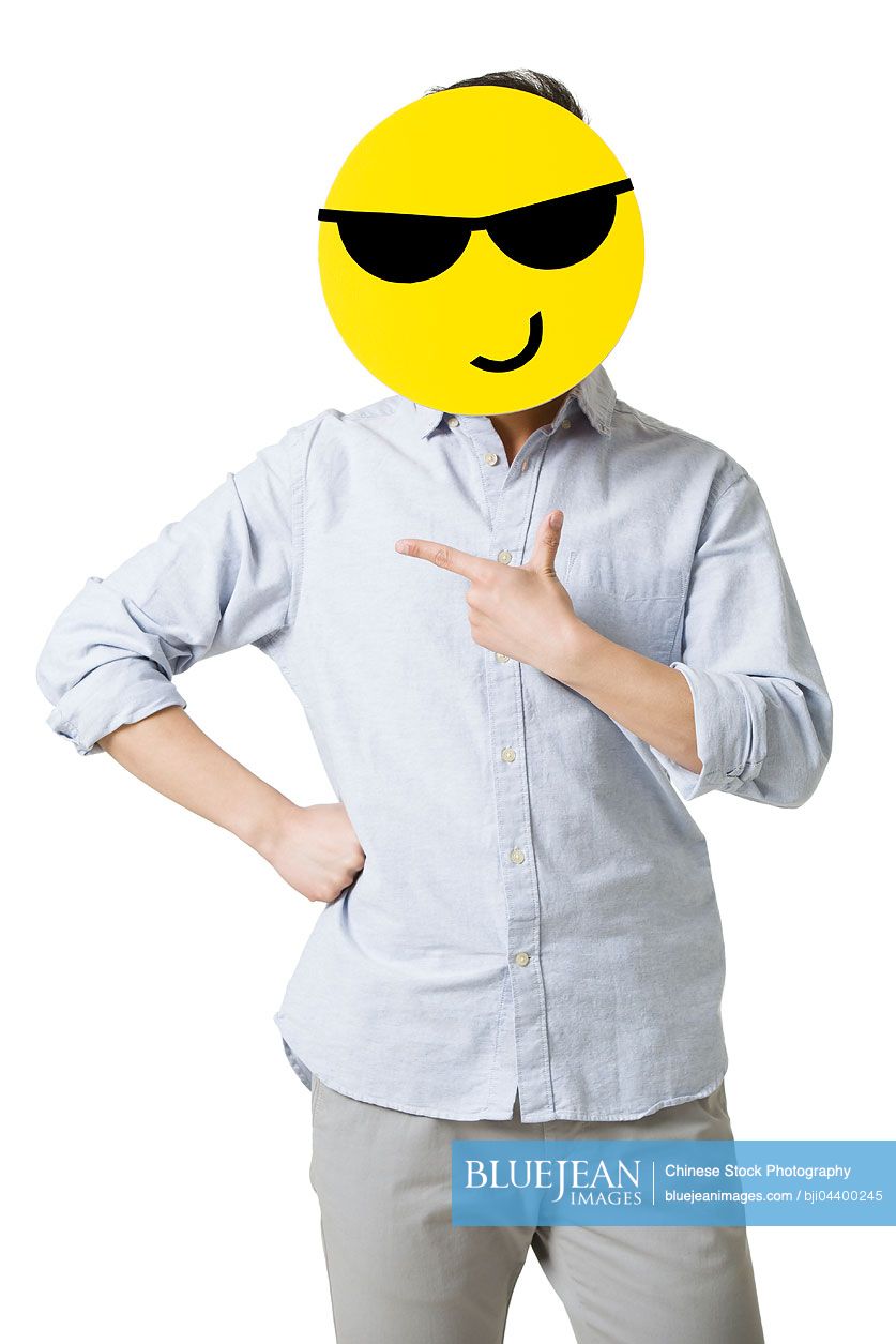 Young Chinese man with a cool emoticon face in front of his face
