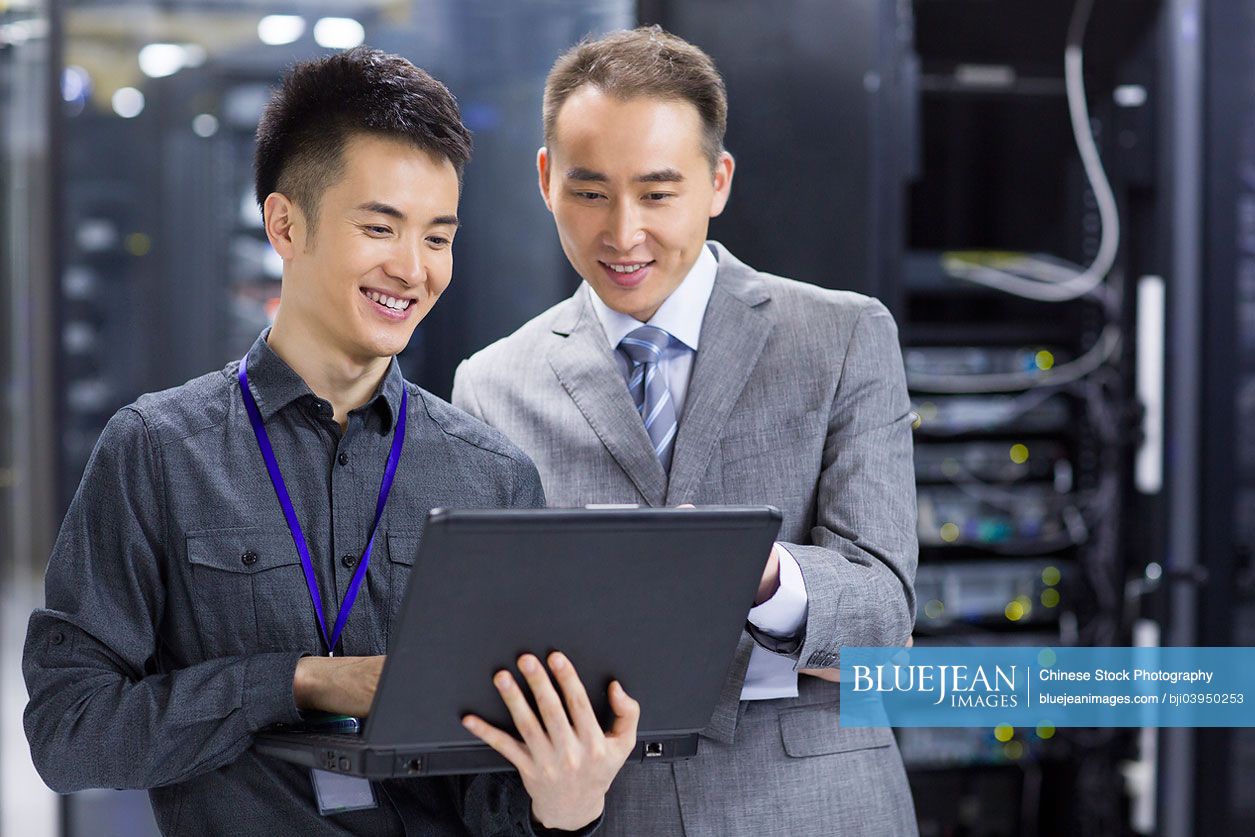 Technician using laptop in computer room