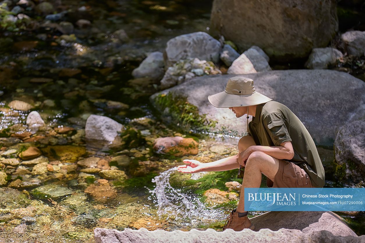 Man playing with the flowing stream water