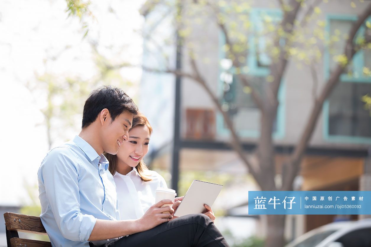 年轻商务人士在户外使用平板电脑