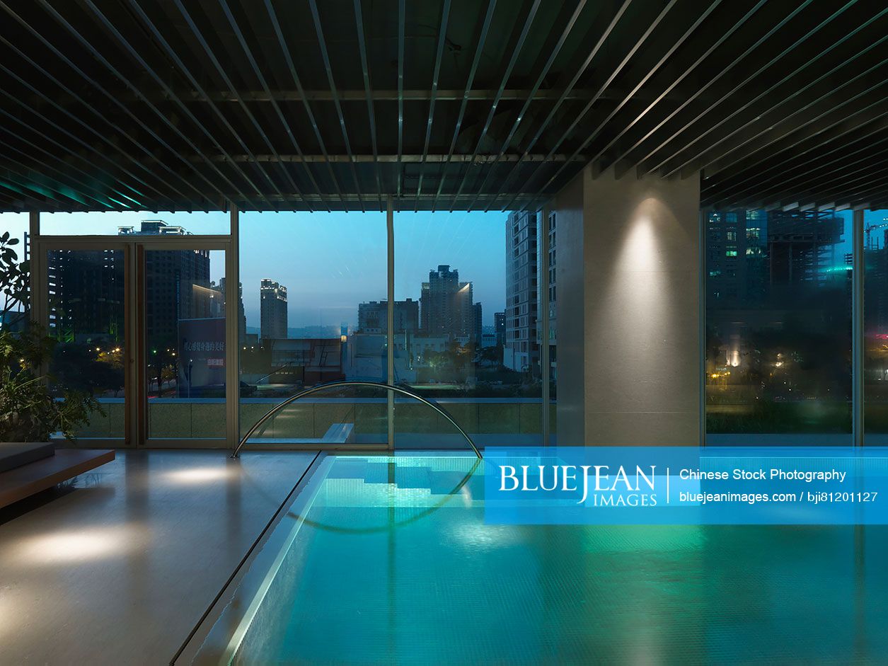 Indoor pool with view of downtown at dusk