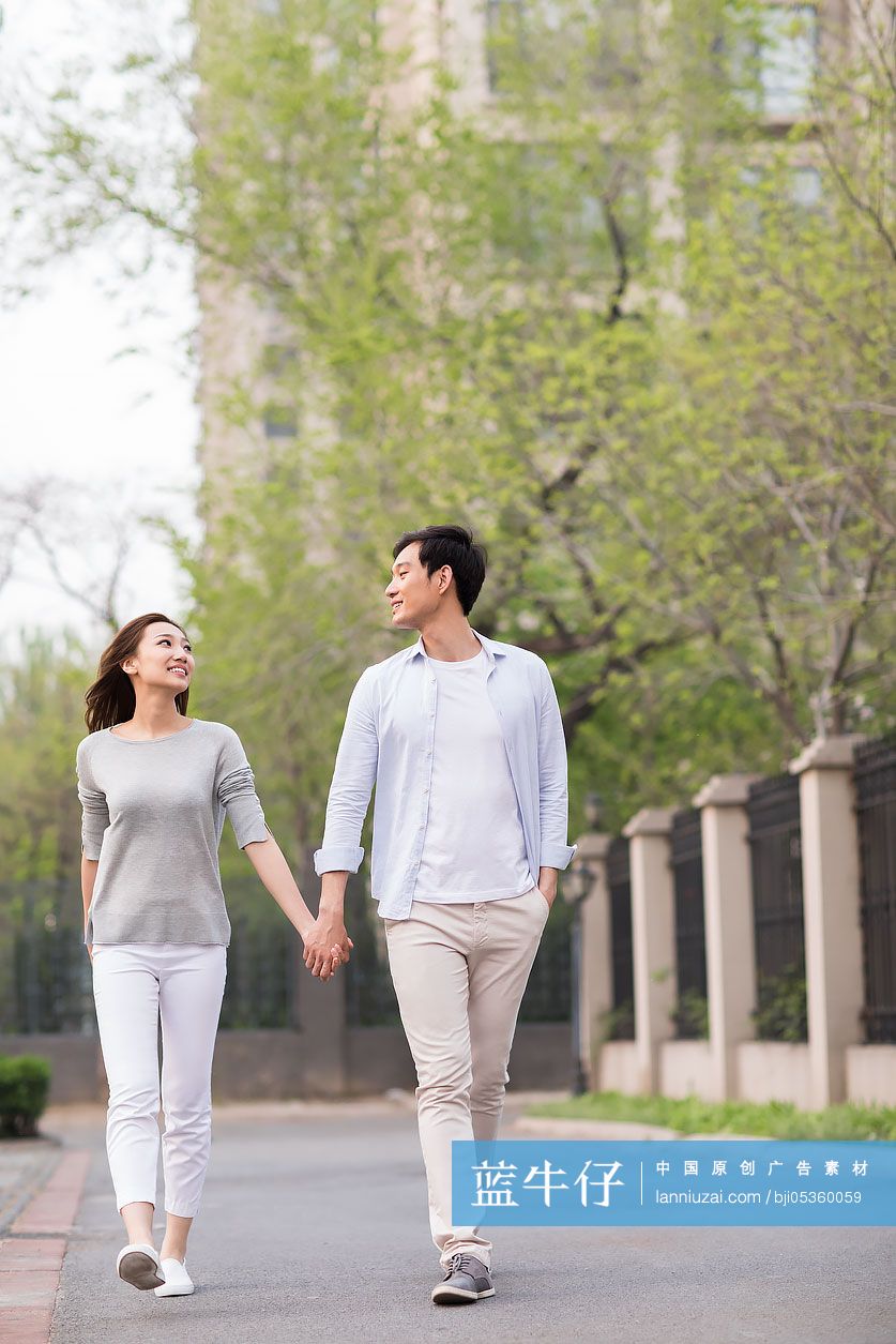 快乐的年轻情侣手牵手散步