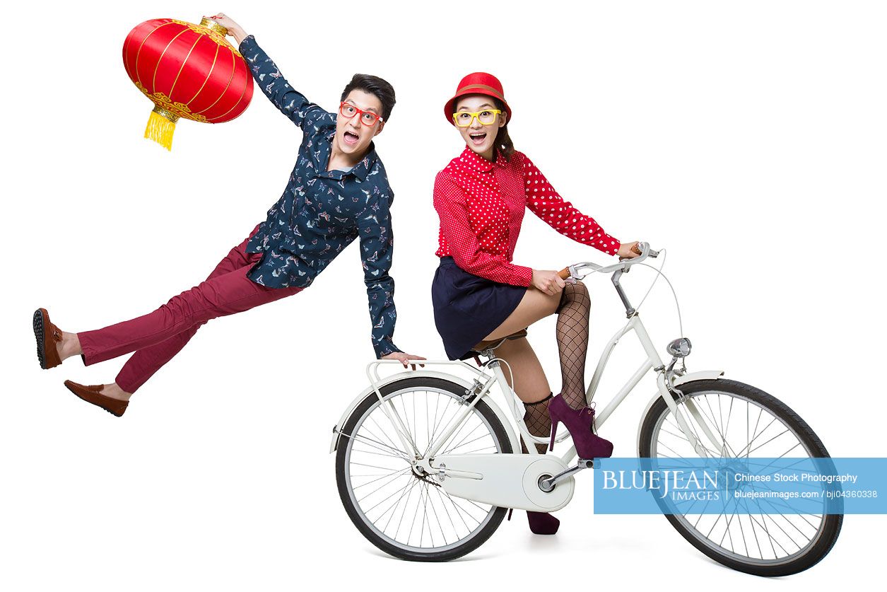 Young couple riding on a bike with Chinese lantern