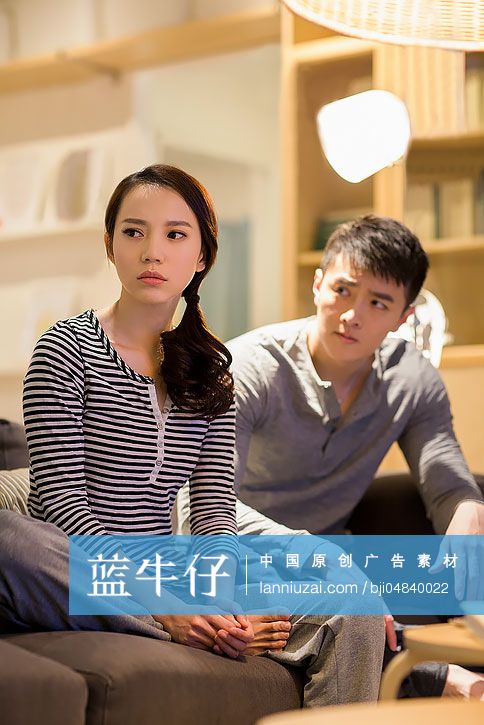 年轻情侣在客厅沙发上争吵