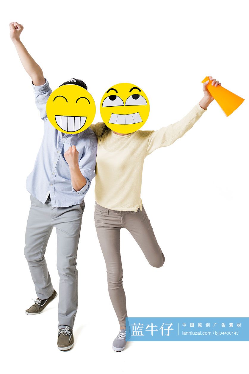 年轻情侣戴着卡通笑脸欢呼