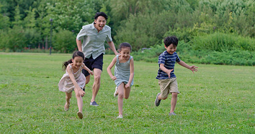 Happy young Chinese family running on grass,4K