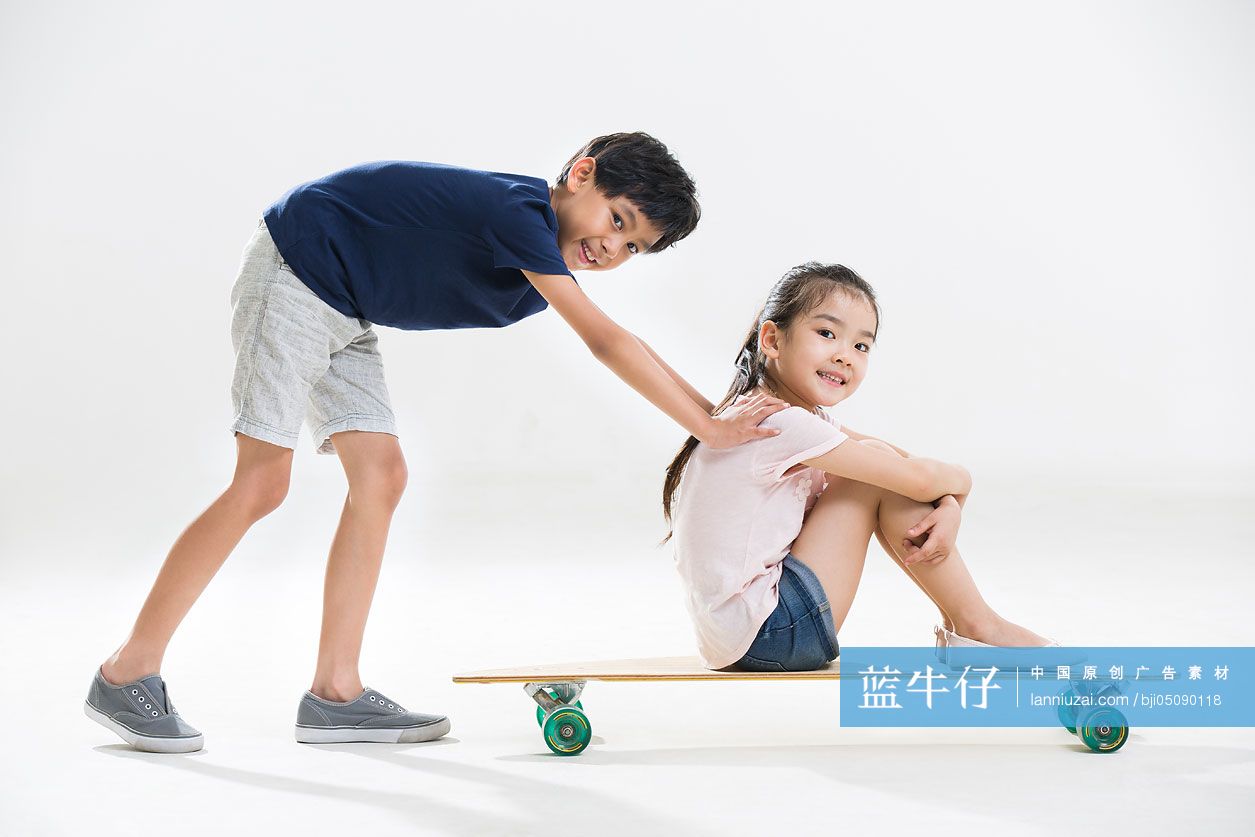 可爱的小男孩和小女孩玩滑板