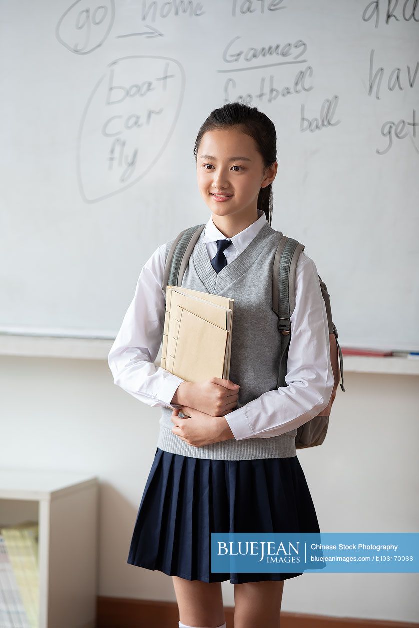 Chinese schoolgirl standing in classroom