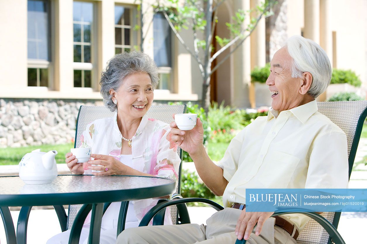 Senior Chinese couple chatting and having tea