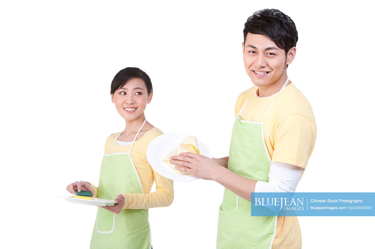 Young Chinese couple cleaning plates