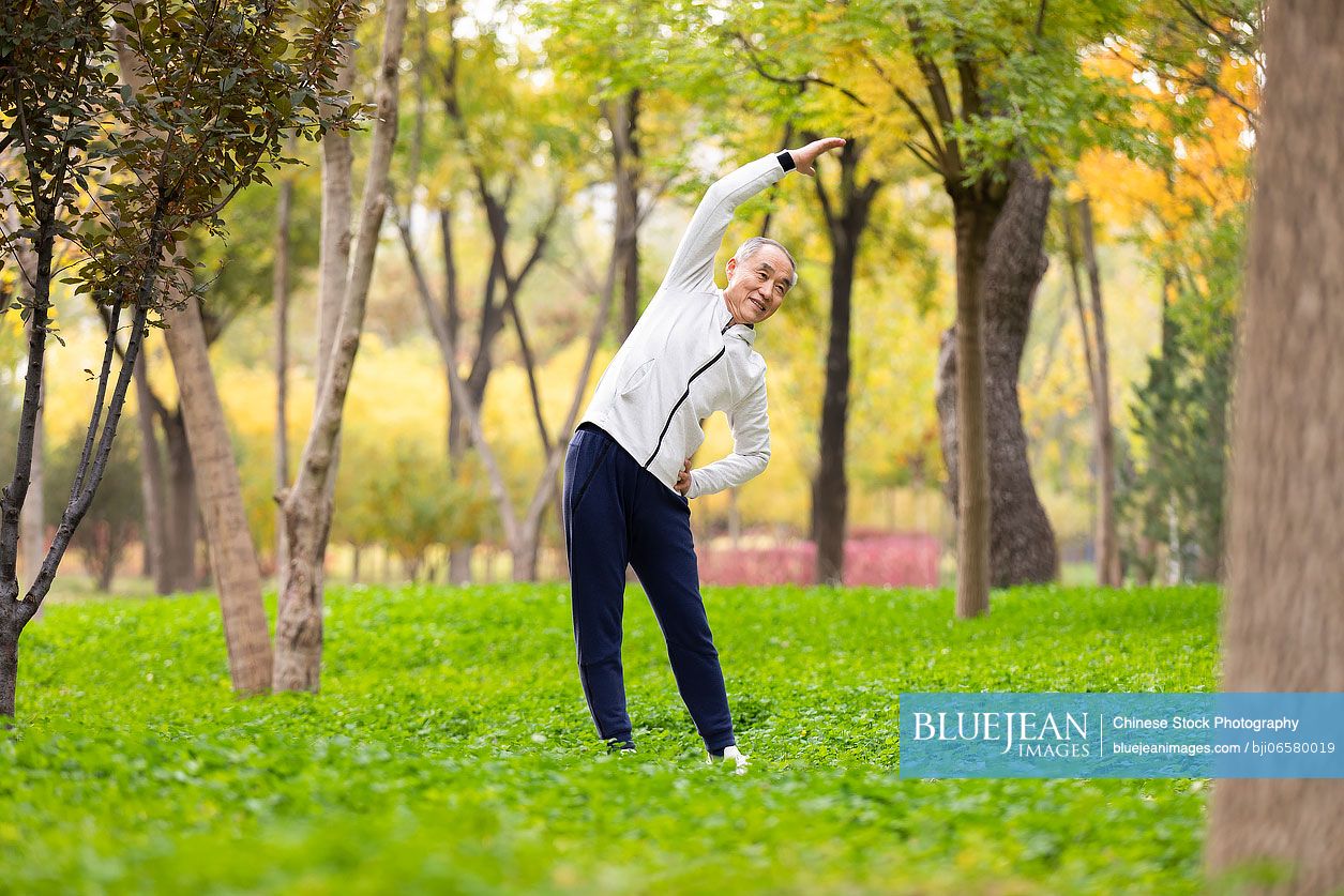 Happy senior Chinese man exercising in the park