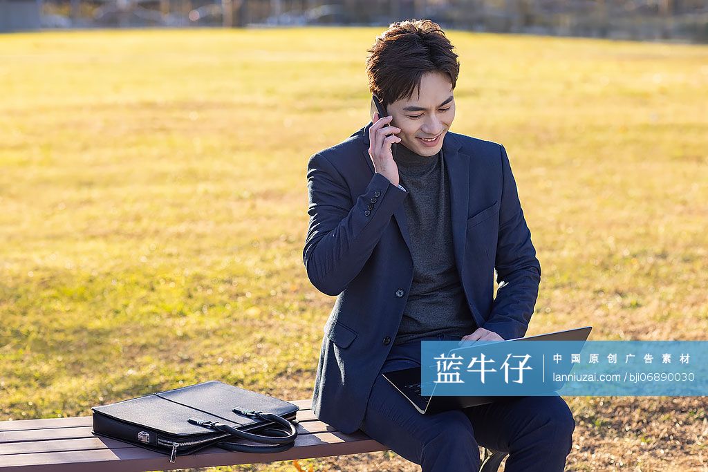 商务男子在户外使用笔记本电脑