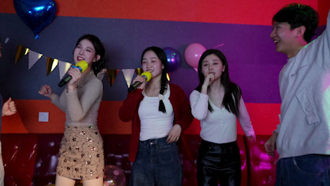 Young friends having fun at birthday karaoke party