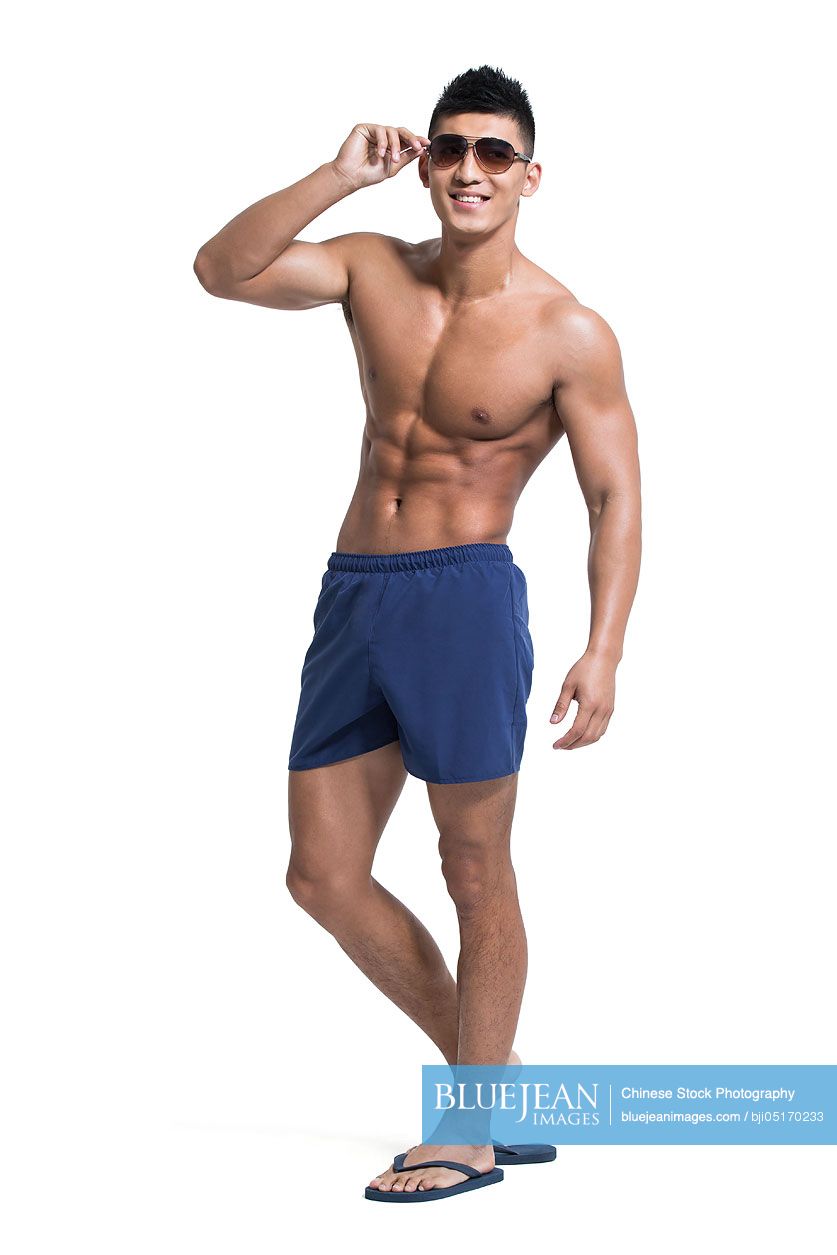 Young Chinese muscular man wearing swimming trunks