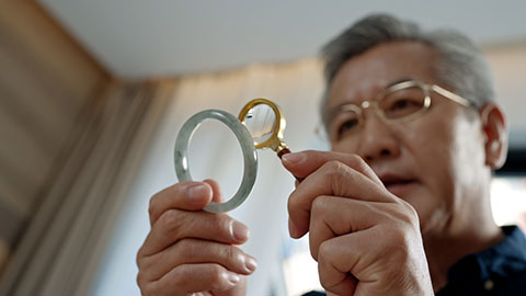 老年男子在家里鉴定古董