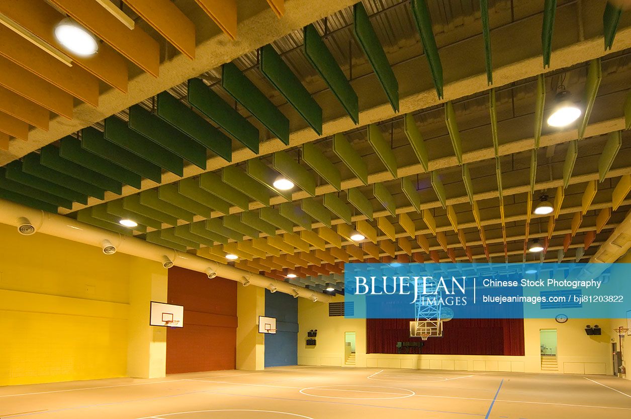 Empty indoor basketball court with paneled ceiling