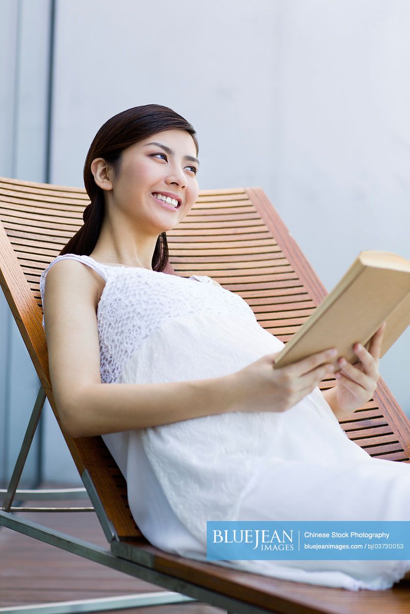 Pregnant Chinese woman reading a book