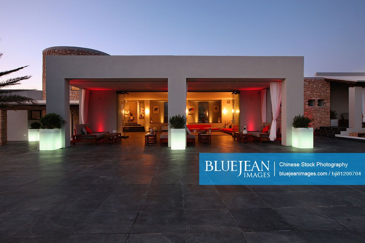 Red lights illuminating outdoor seating area at dusk