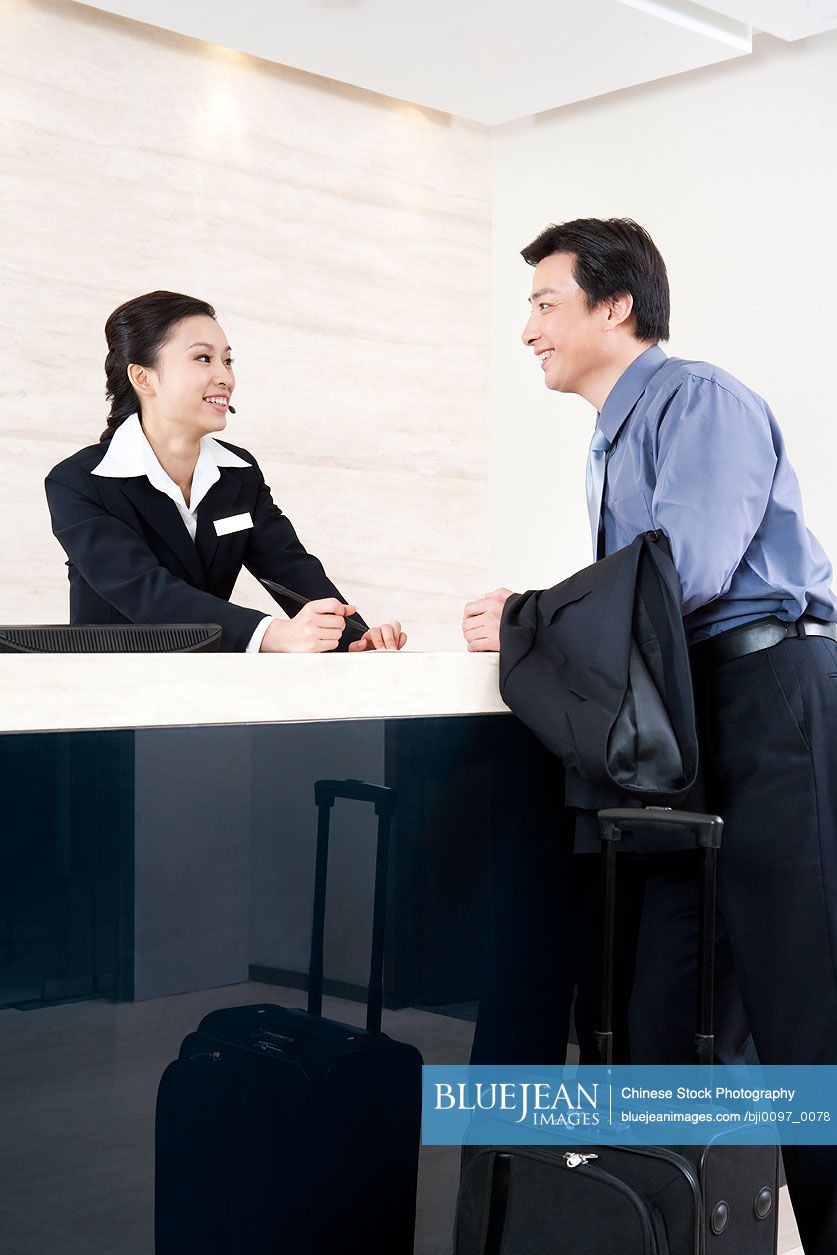 Chinese Man And Hotel Receptionist In Foyer