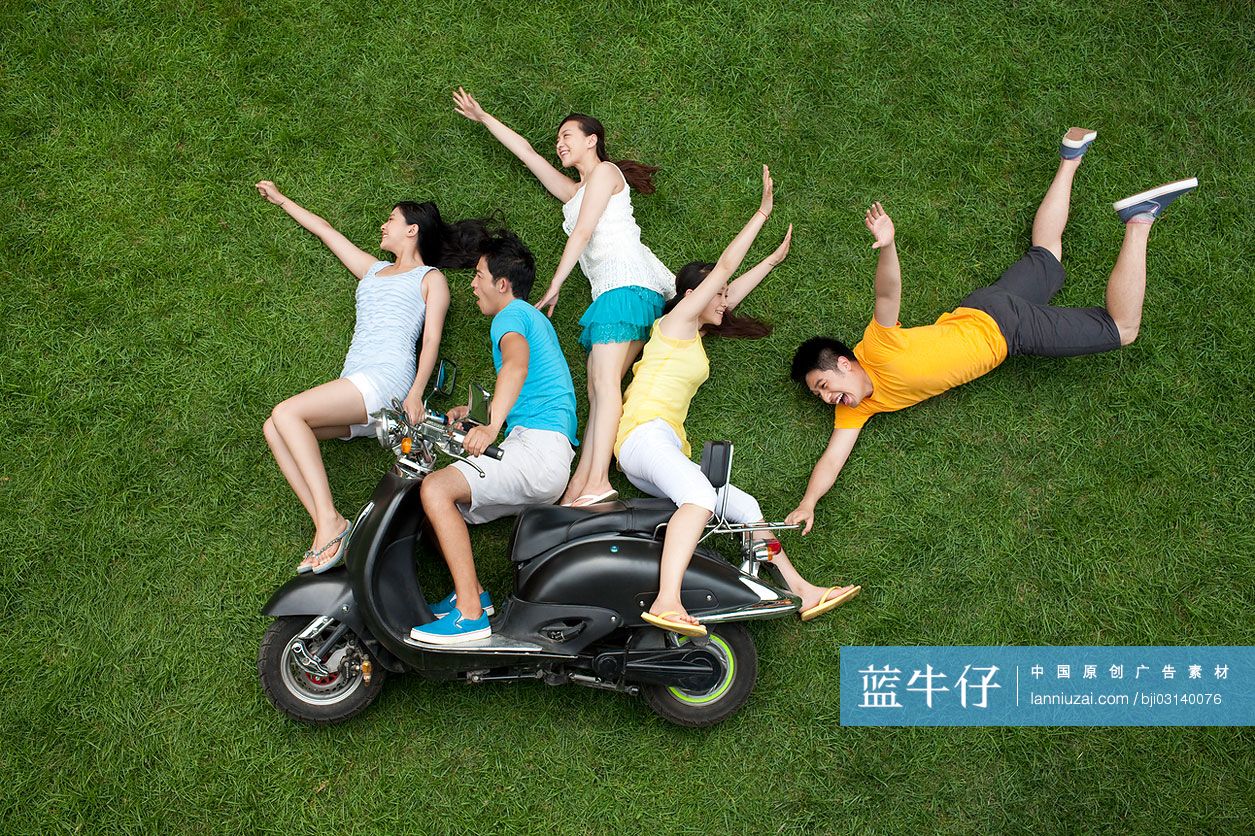 创意男女在草地上模仿骑摩托车