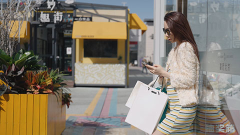 Cheerful young Chinese woman walking with shopping bags,4K