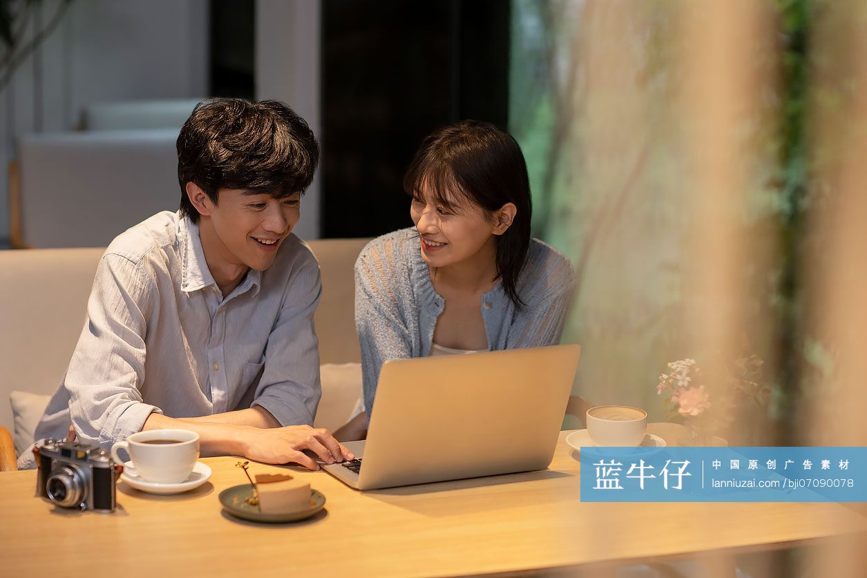年轻情侣在咖啡馆使用笔记本电脑-蓝牛仔影像-中国原创广告影像素材