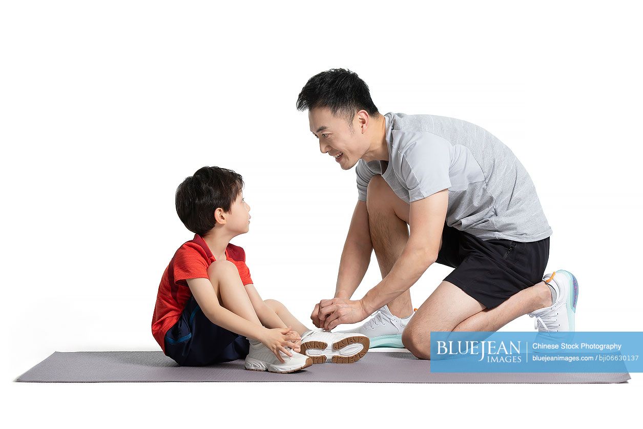 Little Chinese boy exercising with his father