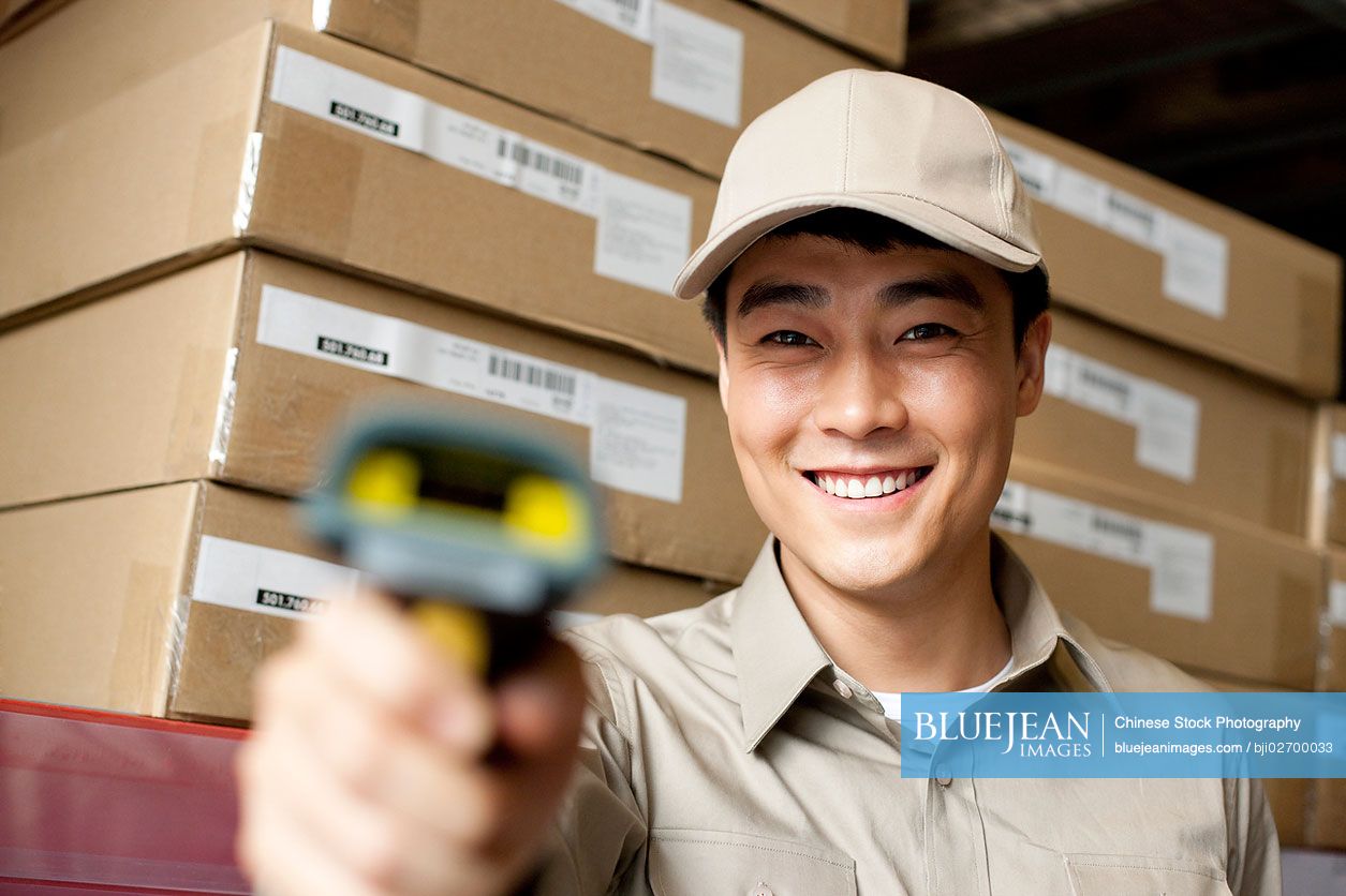 Male Chinese warehouse worker with scanner