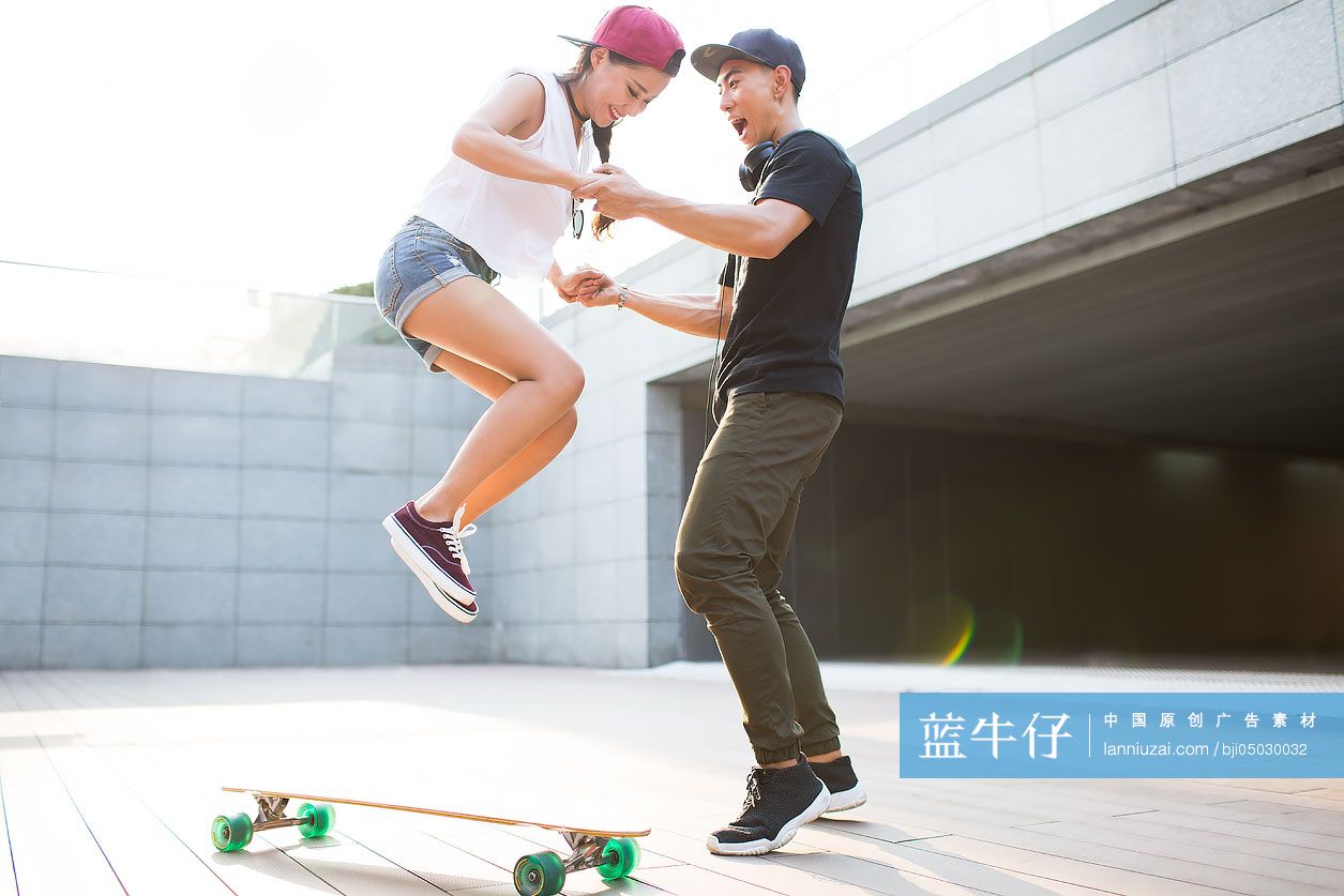 年轻男子教女朋友滑滑板