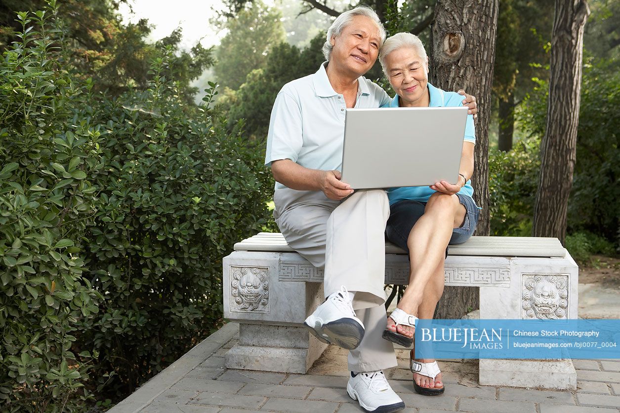 Old Chinese Couple Looking At Laptop Together