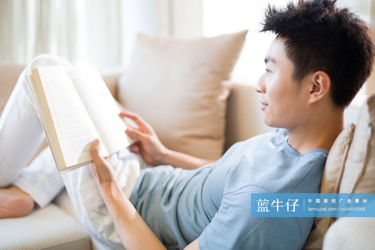 年轻男子在沙发上看书