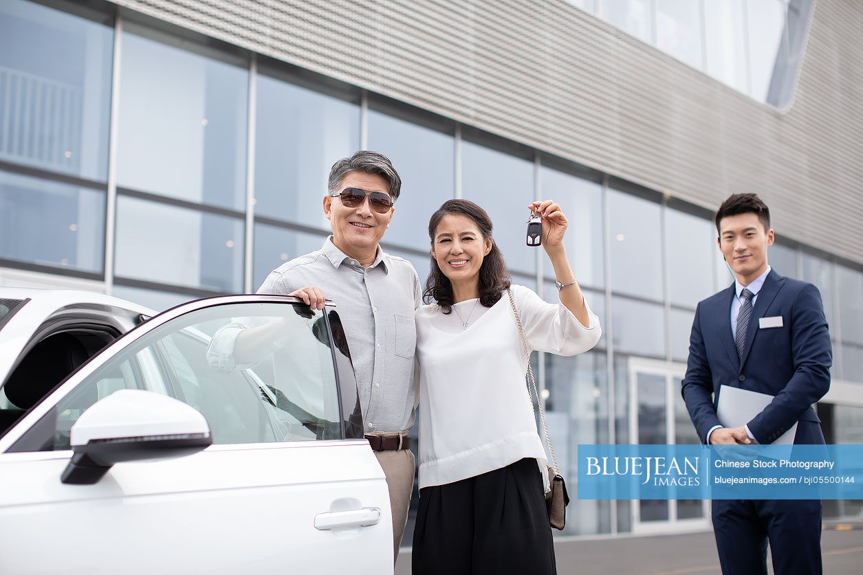 Happy mature Chinese couple buying car