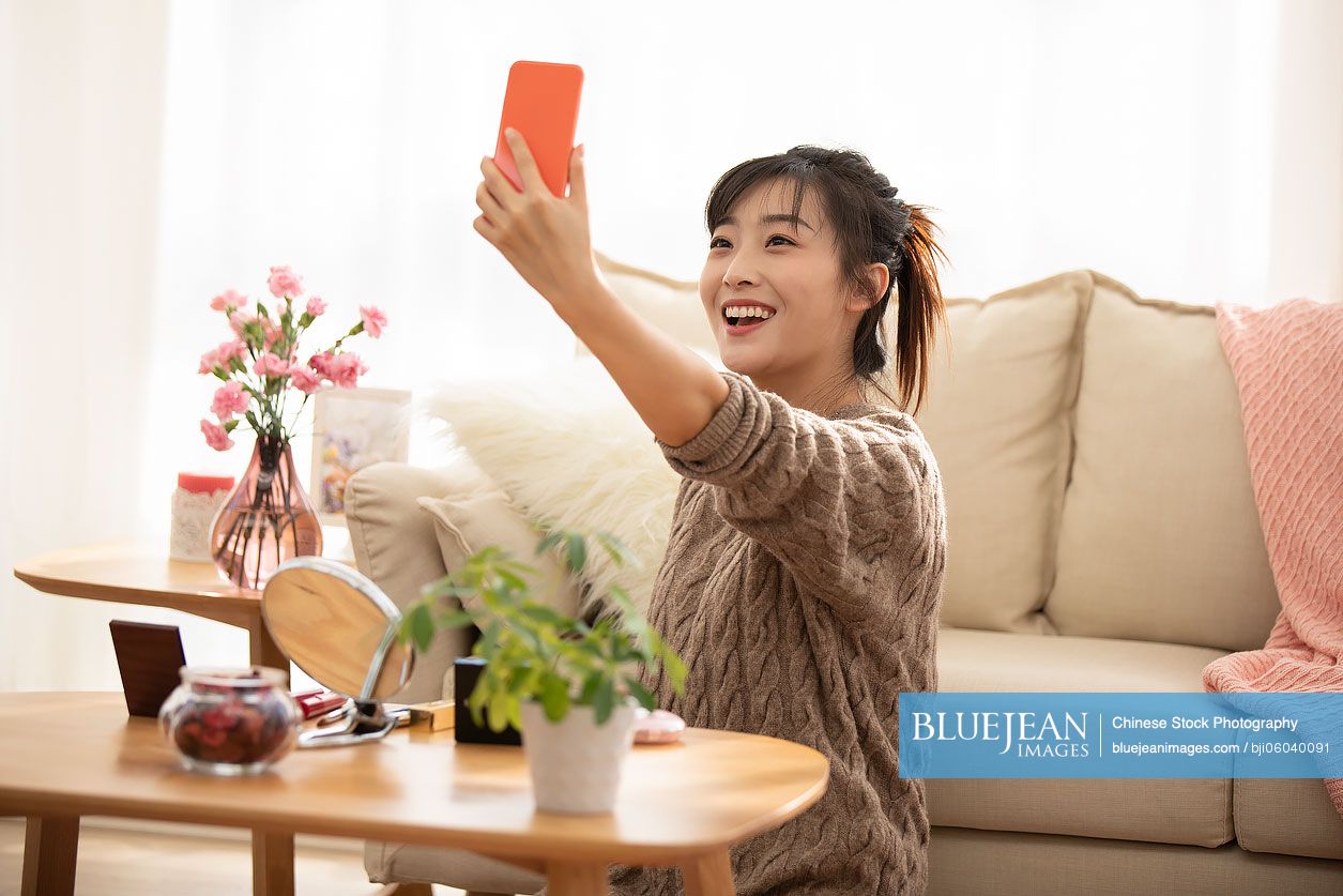 Young Chinese woman doing live webcast at home