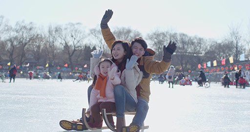 Happy young Chinese family sitting on sled,4K