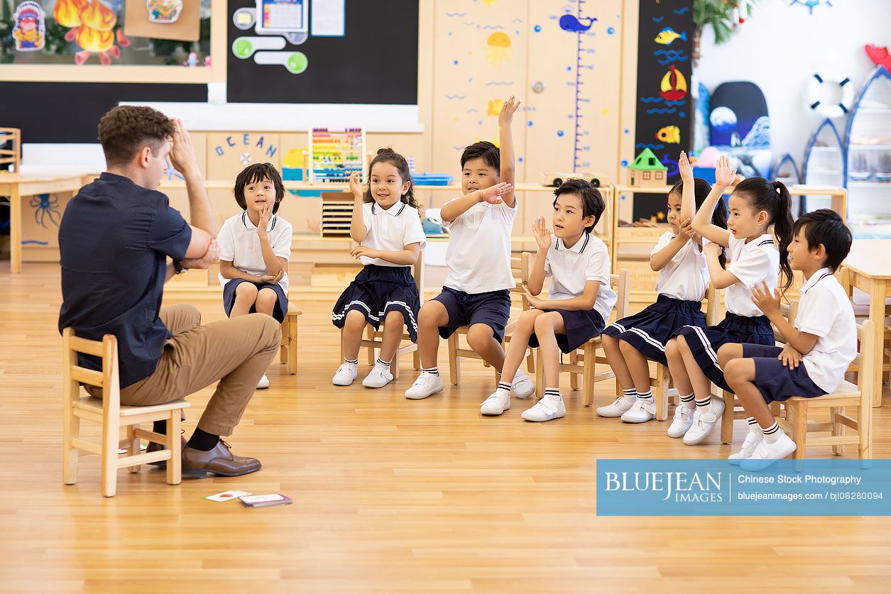 Foreign teacher teaching children English in classroom