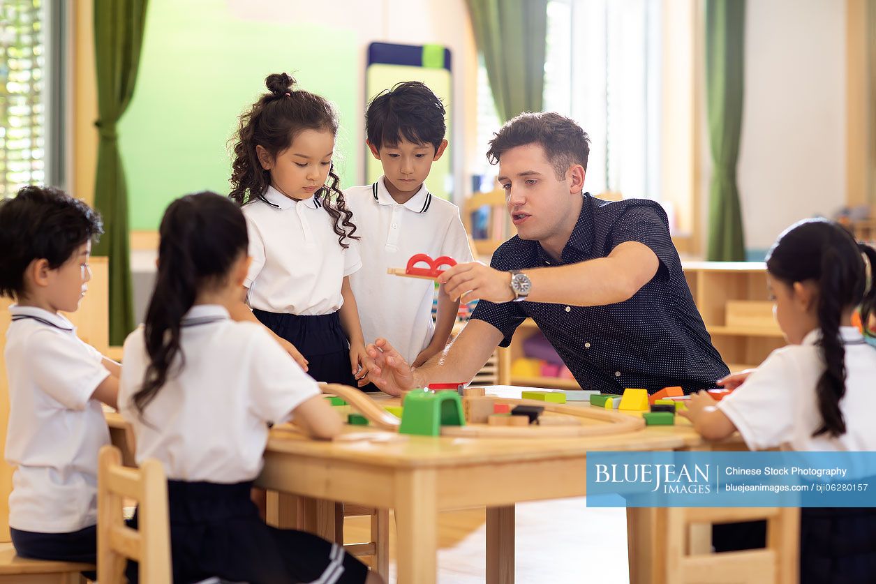 Foreign teacher and children playing in classroom
