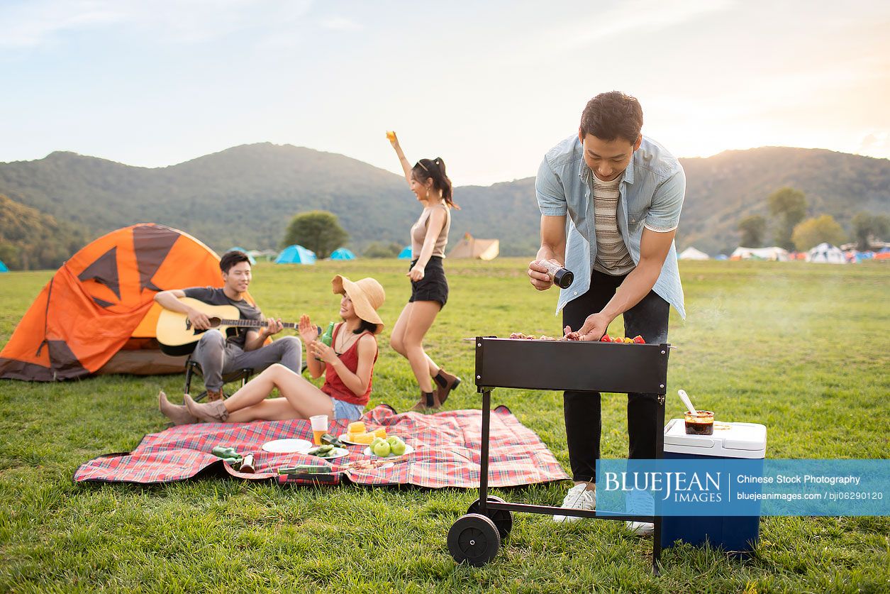 Happy young Chinese friends having a picnic outdoors