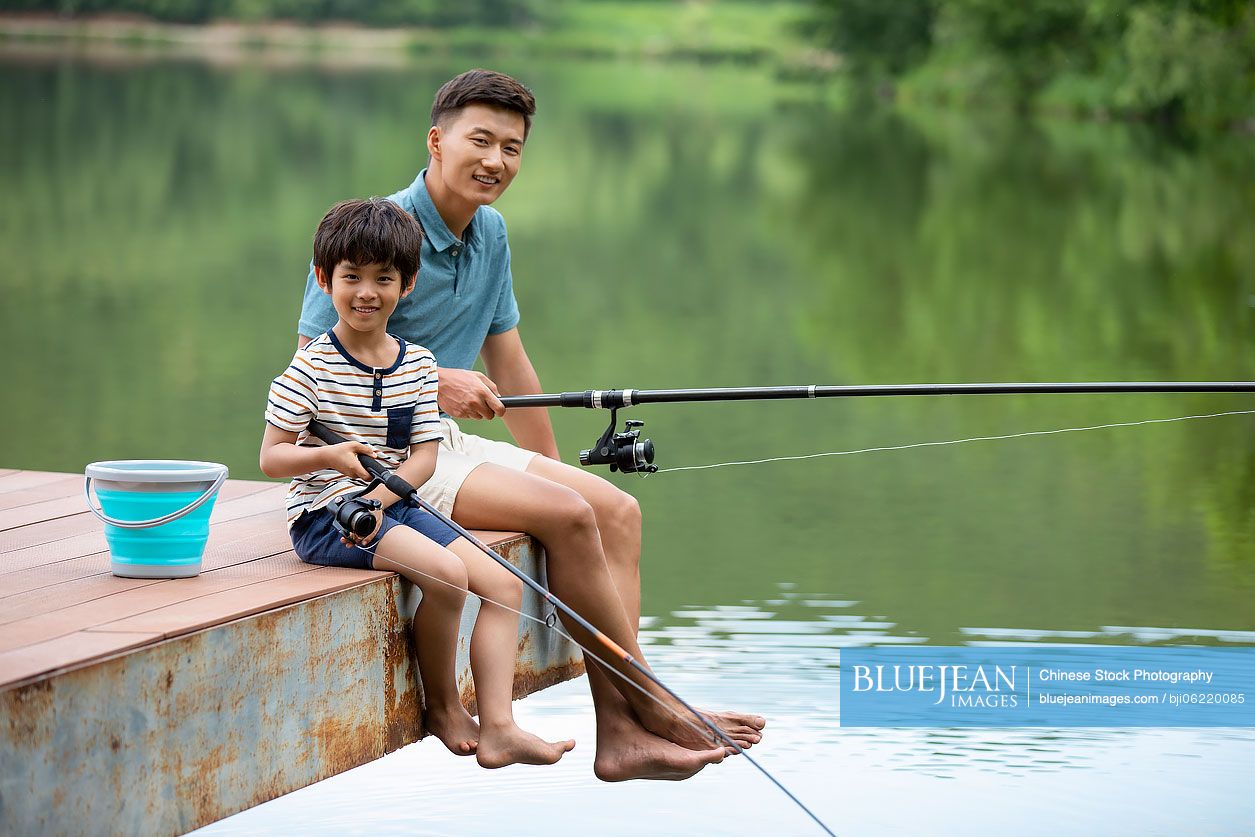 Happy Chinese father and son fishing by the river-High-res stock photo for  download